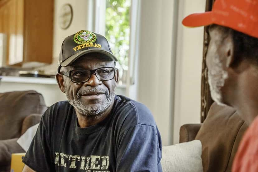 A smiling older veteran wearing a Vietnam veteran cap